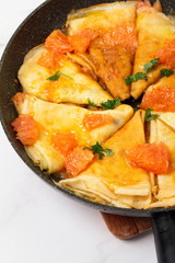 pancakes with sauce in a pan close-up on a white background