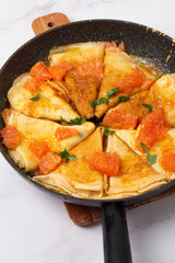 pancakes with sauce in a pan close-up