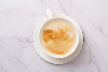 cappuccino in a white cup on a white background top view