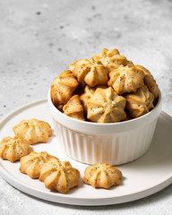 Lemon cookies with poppy seeds in a white ceramic bowl on the gray kitchen table. Shortbread. Space for text