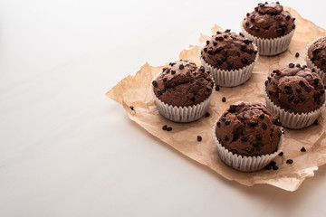 fresh chocolate muffins on parchment paper