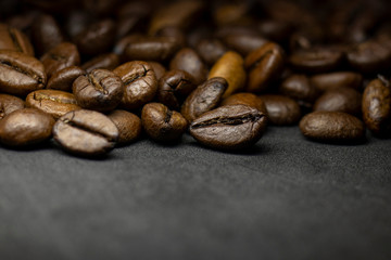 Coffee in beans on dark background. Abstract background texture.Coffee beans texture. Food background of coffee beans