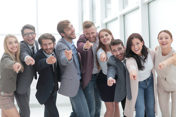 Obraz premium grupa szczęśliwych młodych ludzi biznesu, wskazując na Ciebie