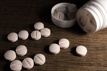 White medical pills and tablets with bottle