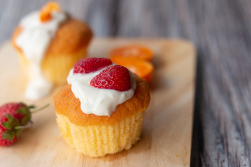 Pieces of orange, strawberry cake on wooden plate, bakery and food.