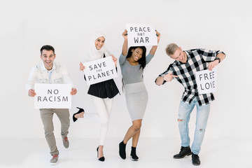 Young happy four multiethnical friends, activists, volunteers, ecologists with banners shouting...