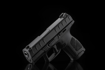 Black gun pistol on dark  background. Short-barreled weapons for sports and self-defense. Armament...