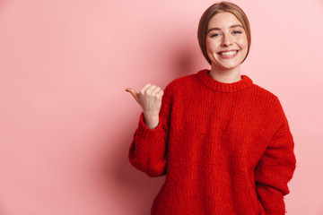 Photo of excited beautiful woman smiling and pointing finger aside