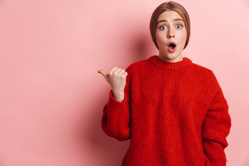Photo of shocked woman expressing surprise and pointing finger aside
