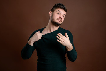 Young man arranges his collar from his blouse