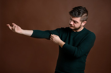 Young man arranges his sleeve from his blouse