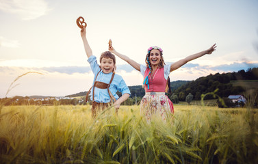 Happy Mother and Son in Bavaria jumping in a meadow