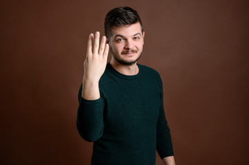 Man with brown hair showing number four