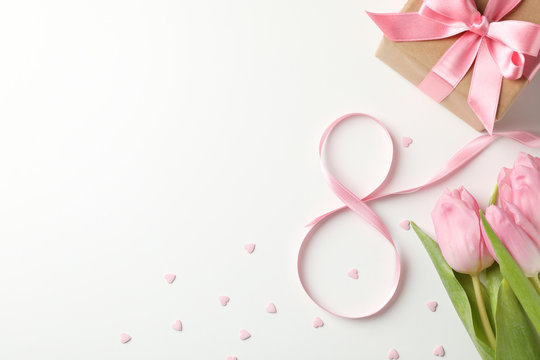 Tulips, gift box, eight made of ribbon and small hearts on white background, space for text