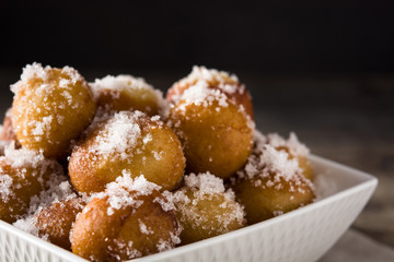 Carnival fritters or buñuelos de viento for holy week on wooden table close up