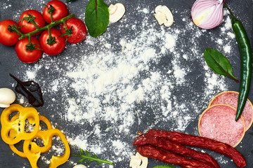 Pizza ingredients on dark floury background. Place for text.