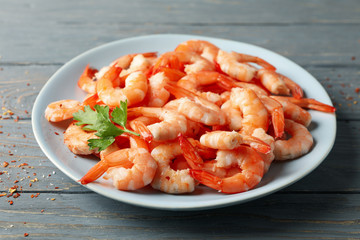 Plate with shrimps on wooden background, close up