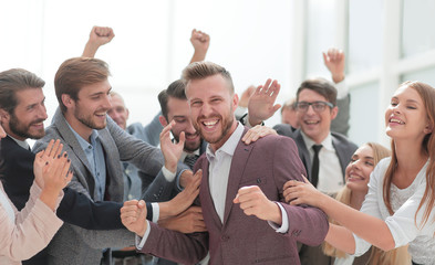 close up. cheerful company employees congratulating their colleague