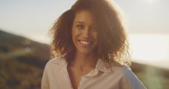Portrait of a happy carefree african american woman smiling and enjoying herself at sunset, happy person at sunset