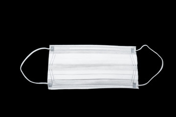 A white surgical mask for protection of infection on the black background