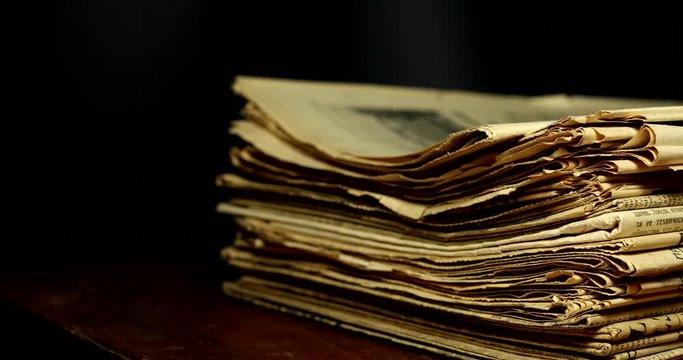 Stop motion a stack of old yellowed newspapers information transfer concept.