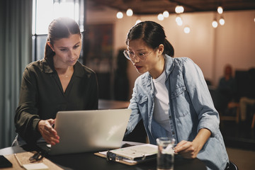 Diverse businesswomen working together on a laptop in an office
