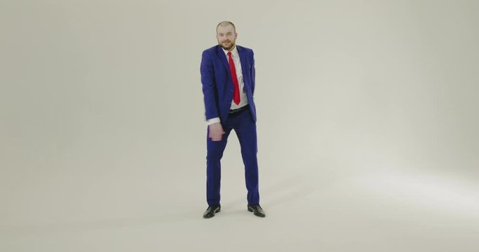 Young, confident and smartly dressed businesman performing floss dance on a white background - Slow Motion, Wide Shot 