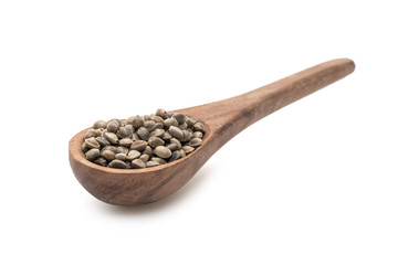 Brown wooden spoon with hemp seeds seen obliquely from the front and isolated on white background