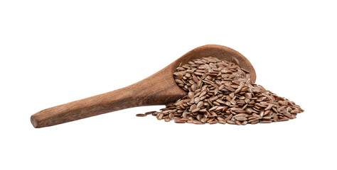 Side view of linseeds or flax seed on a tilted brown wooden spoon with spill and handle from left isolated on white background