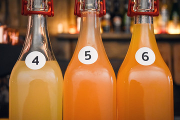 Closeup three glass bottles numbered four, five and six, with alcohol cocktails, beverages or...