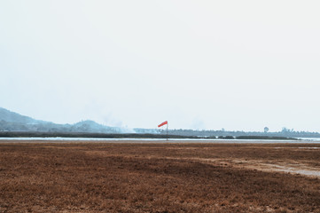 Red wind sock beside runways on small airfield