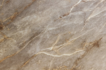 Brown-white marbled pattern with gold streaks. Abstract texture and background.