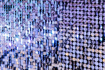 Obraz premium Event Decoration On Photo Zone. Press Wall Made Of Many Round Sparkling Sequins. Bright Abstract Background of bestirring tinsel