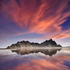 Panorama of Famous Stokksnes mountain reflected in water on Vestrahorn cape (Batman Mountain),...