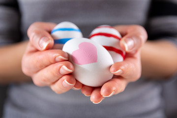 Girl hands with Easter colorful eggs. Girl holding group of painting eggs in hands indoor. Easter holiday concept. Close up, selective focus