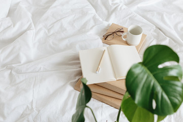 Books on bed white bed linen.
