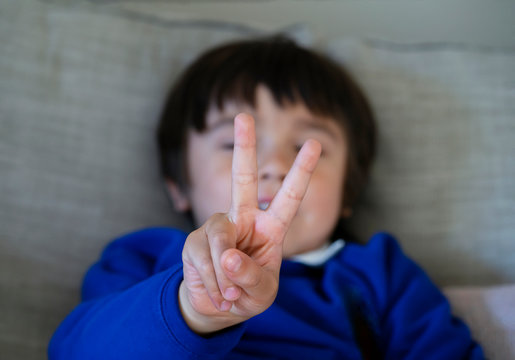 Blurry Face A Boy Showing His Fingers At Camera,Selective Focus Of Kid Primary School Counting Number Second,Cute Kid Showing Numbers Two With Fingers,Education Or Toddler Development Concept