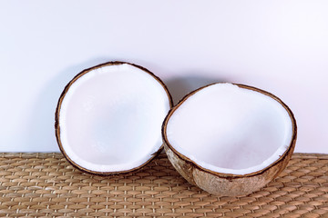 Open fresh coconut close up on seagrass mat background.