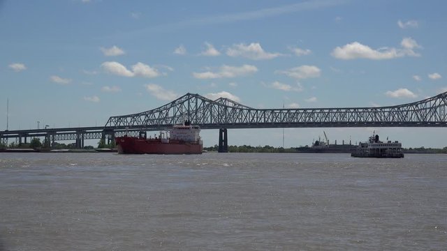 Ferry & freighter at  Mississippi river with the Crescent City Connection bridge at background. New Orleans, Louisiana, USA