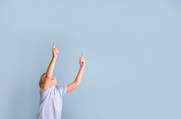 positive blond boy having fun on a blue background, the concept of a happy and joyful childhood