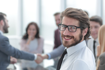 portrait of a successful young businessman on the background of the office.