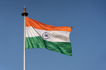 Waving Flag of India on a Flag Poll Against Blue Sky