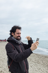 man greeting by phone by the sea