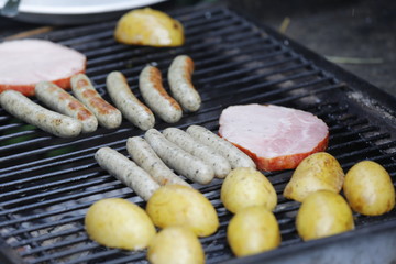 Barbecue Grill mit gegrillten Würstchen, Steak, Kartoffeln, Gemüse