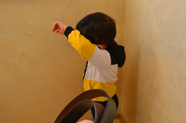 Little child boy wall corner punishment sitting