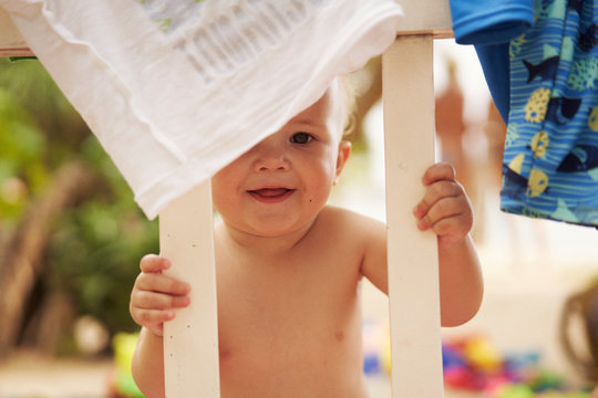Baby looking through cot and smiling