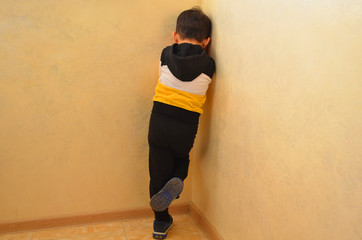 Little child boy wall corner punishment sitting