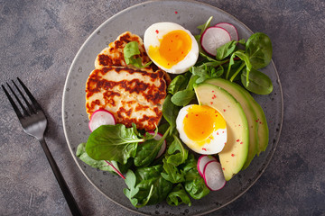 healthy keto paleo diet breakfast: boiled egg, avocado, halloumi cheese, salad leaves