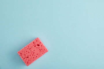 top view of pink sponge for house cleaning on blue with copy space