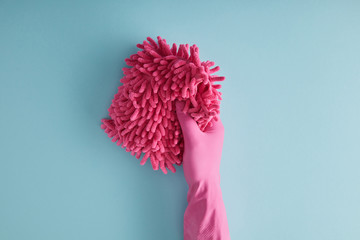 top view of housekeeper in rubber glove holding pink rag on blue